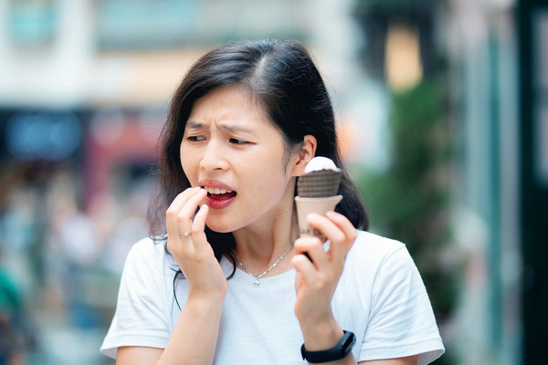 アイスを食べて歯がしみる女性