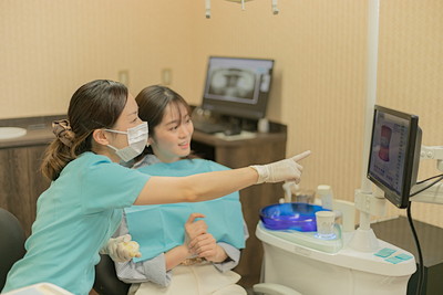 歯の状況を説明する歯科衛生士